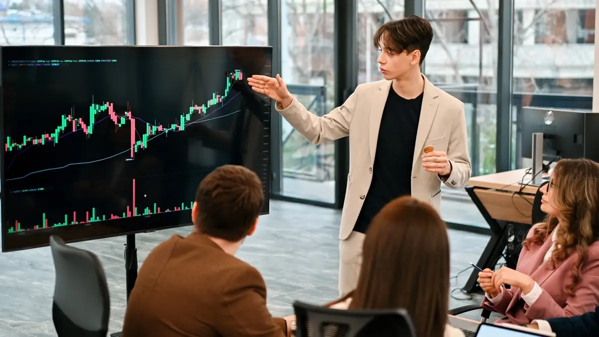 A man leading a finance meeting in a glass office